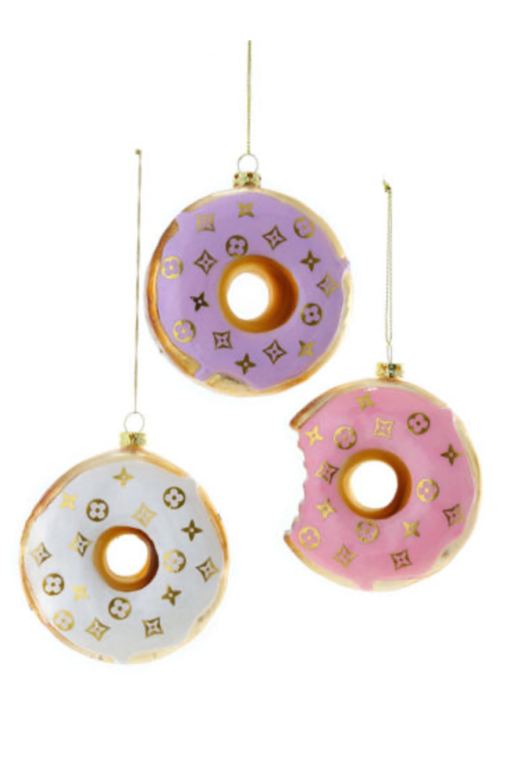 Fashion House Donut Ornaments in pastel colors (lavender, pink, white) with gold detailing, hanging on a tree.