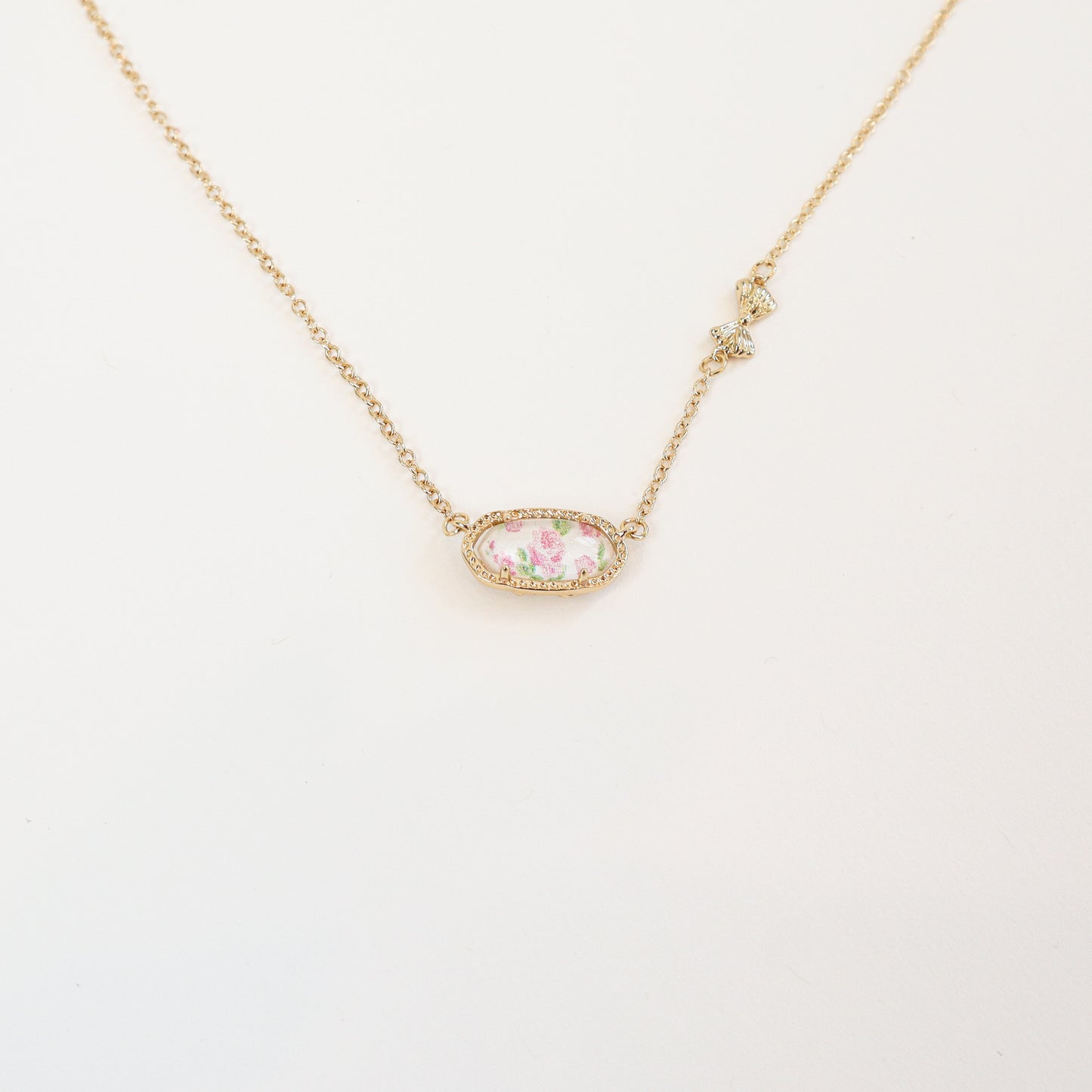 Reversible floral pendant necklace in pink with a vintage-inspired oval charm and gold detailing.