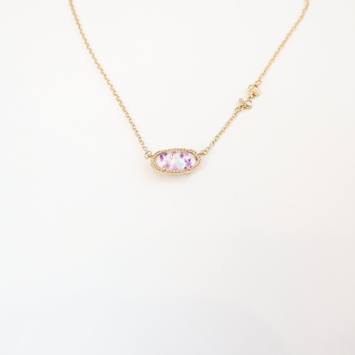 Elegant purple floral pendant necklace with a reversible bow-accented back, offering two unique styles