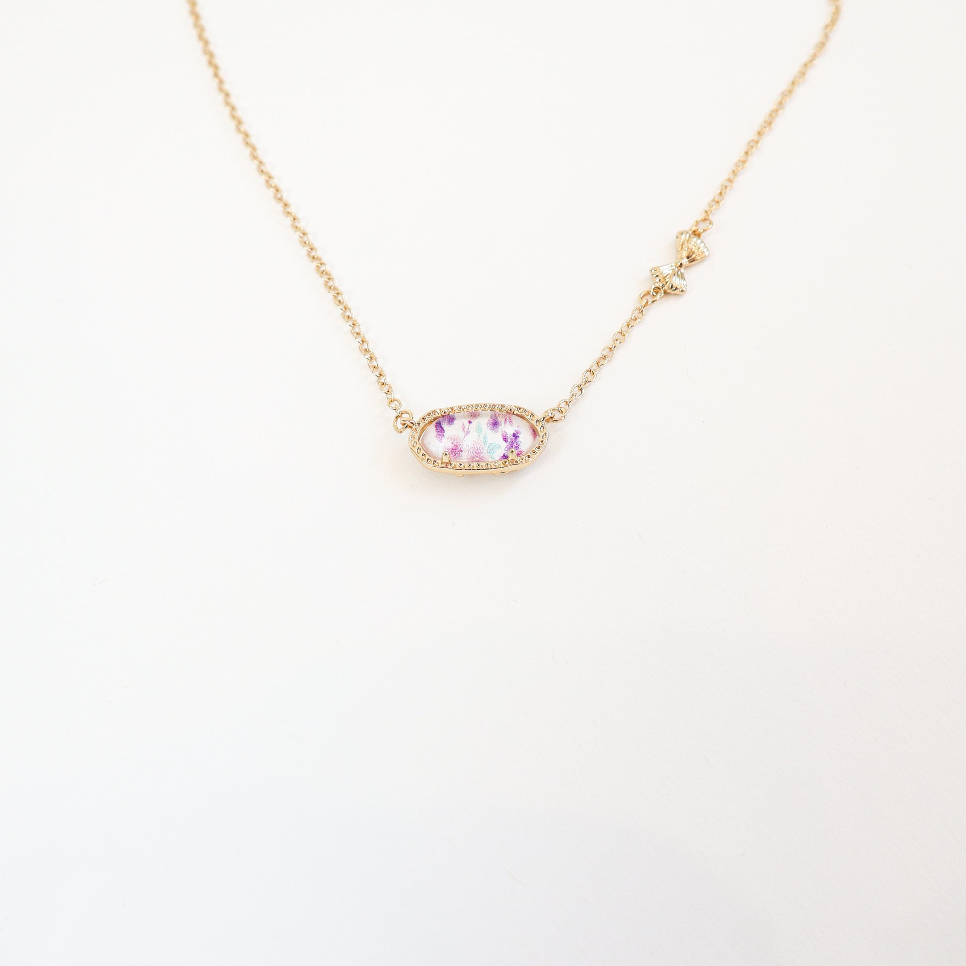 Elegant purple floral pendant necklace with a reversible bow-accented back, offering two unique styles