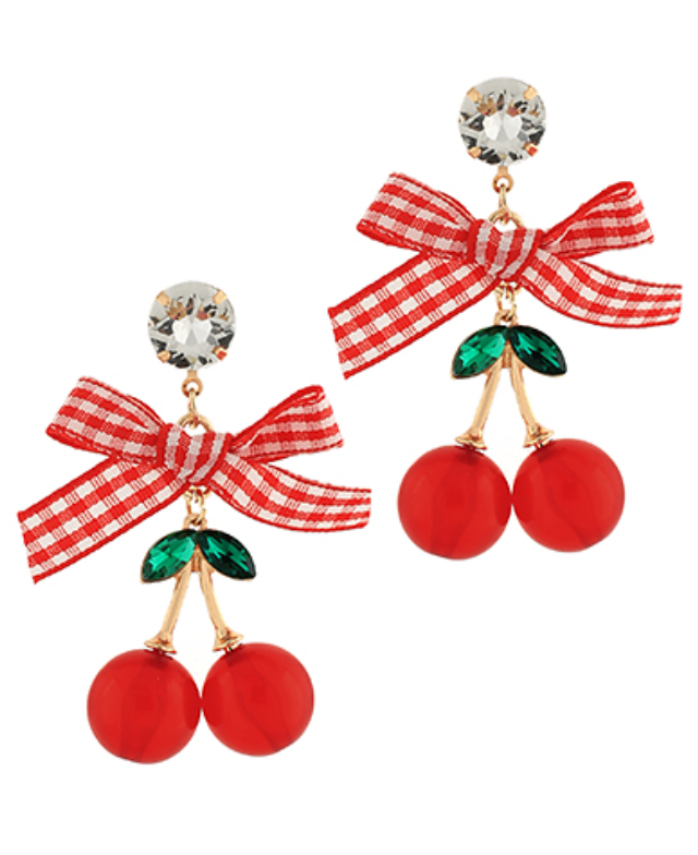 A pair of playful dangle earrings. Each earring features a clear faceted crystal stud, a red and white checkered bow, and two dangling bright red cherry beads with green leaf accents, all connected by gold-toned hardware.