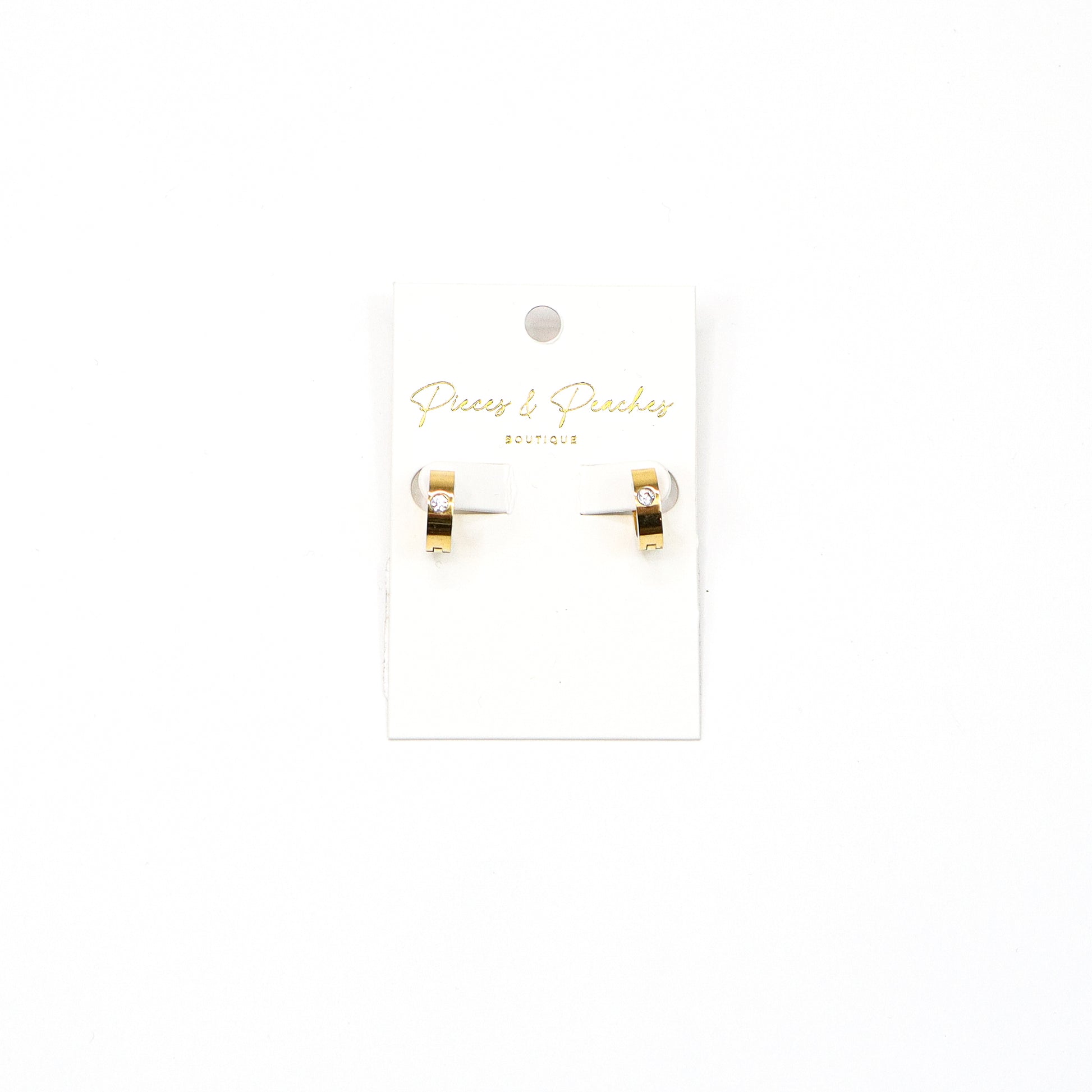 “Gold huggie hoop earrings with a single cubic zirconia stone, featuring a minimalist and modern design for everyday elegance.