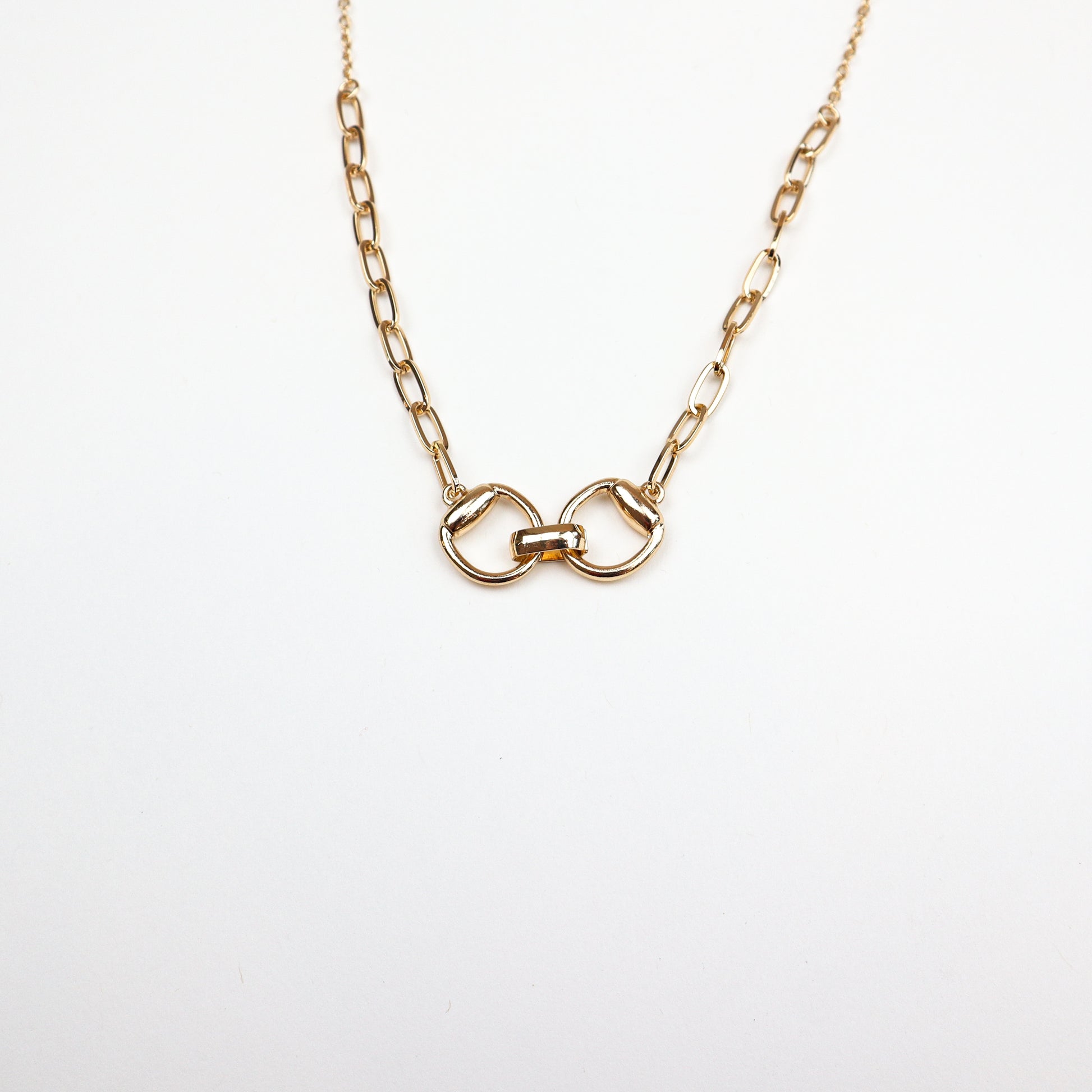  A stylish gold-plated necklace featuring an interlocked belt buckle-inspired pendant, symbolizing strength and connection.
