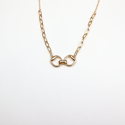  A stylish gold-plated necklace featuring an interlocked belt buckle-inspired pendant, symbolizing strength and connection.
