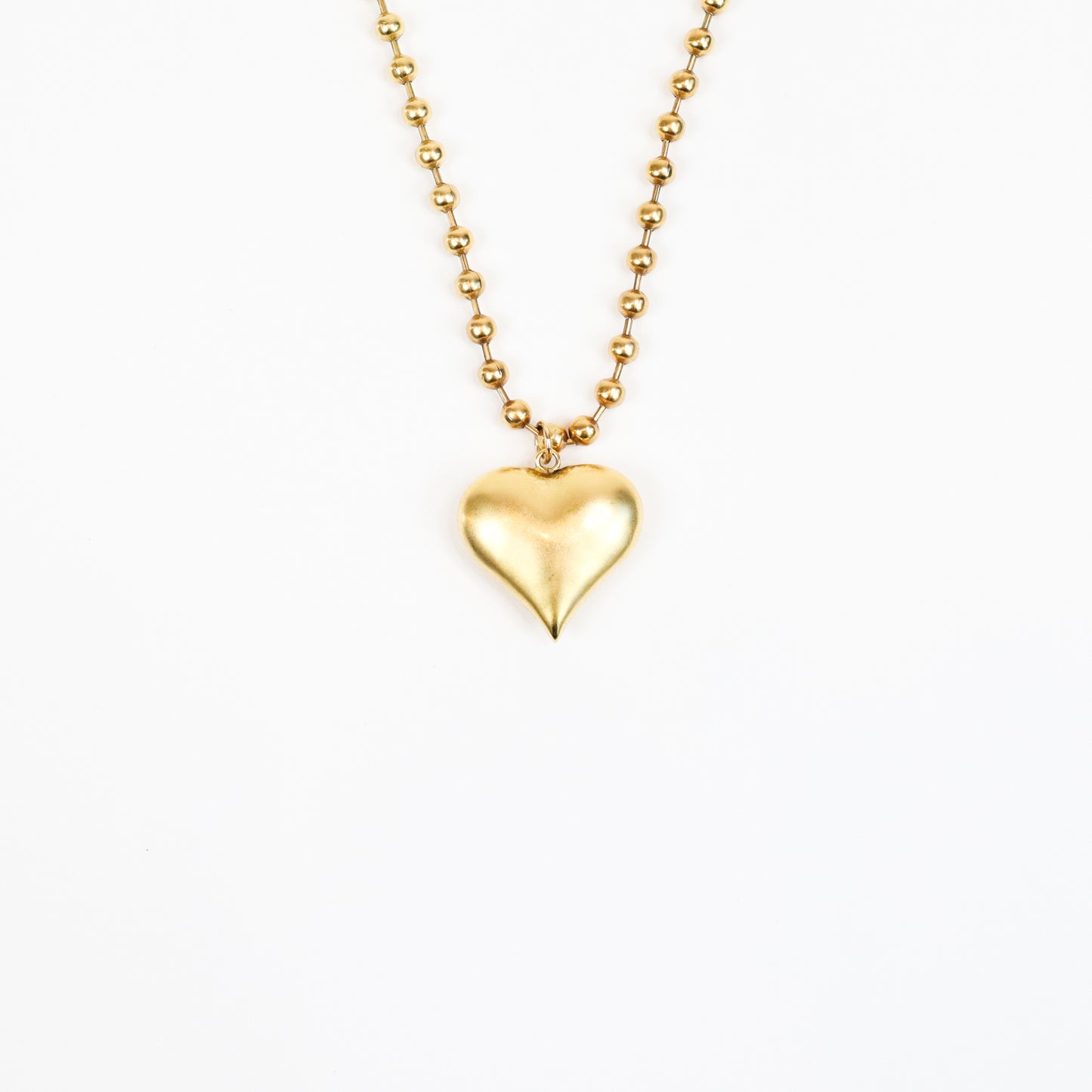 A handcrafted 22K gold-plated heart charm necklace featuring a sculpted heart pendant suspended from a beaded gold chain, radiating timeless elegance and love.