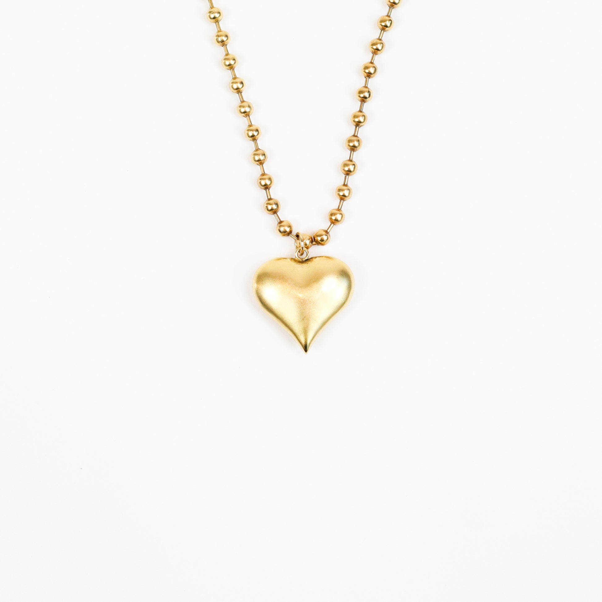 A handcrafted 22K gold-plated heart charm necklace featuring a sculpted heart pendant suspended from a beaded gold chain, radiating timeless elegance and love.