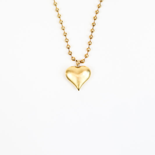 A handcrafted 22K gold-plated heart charm necklace featuring a sculpted heart pendant suspended from a beaded gold chain, radiating timeless elegance and love.