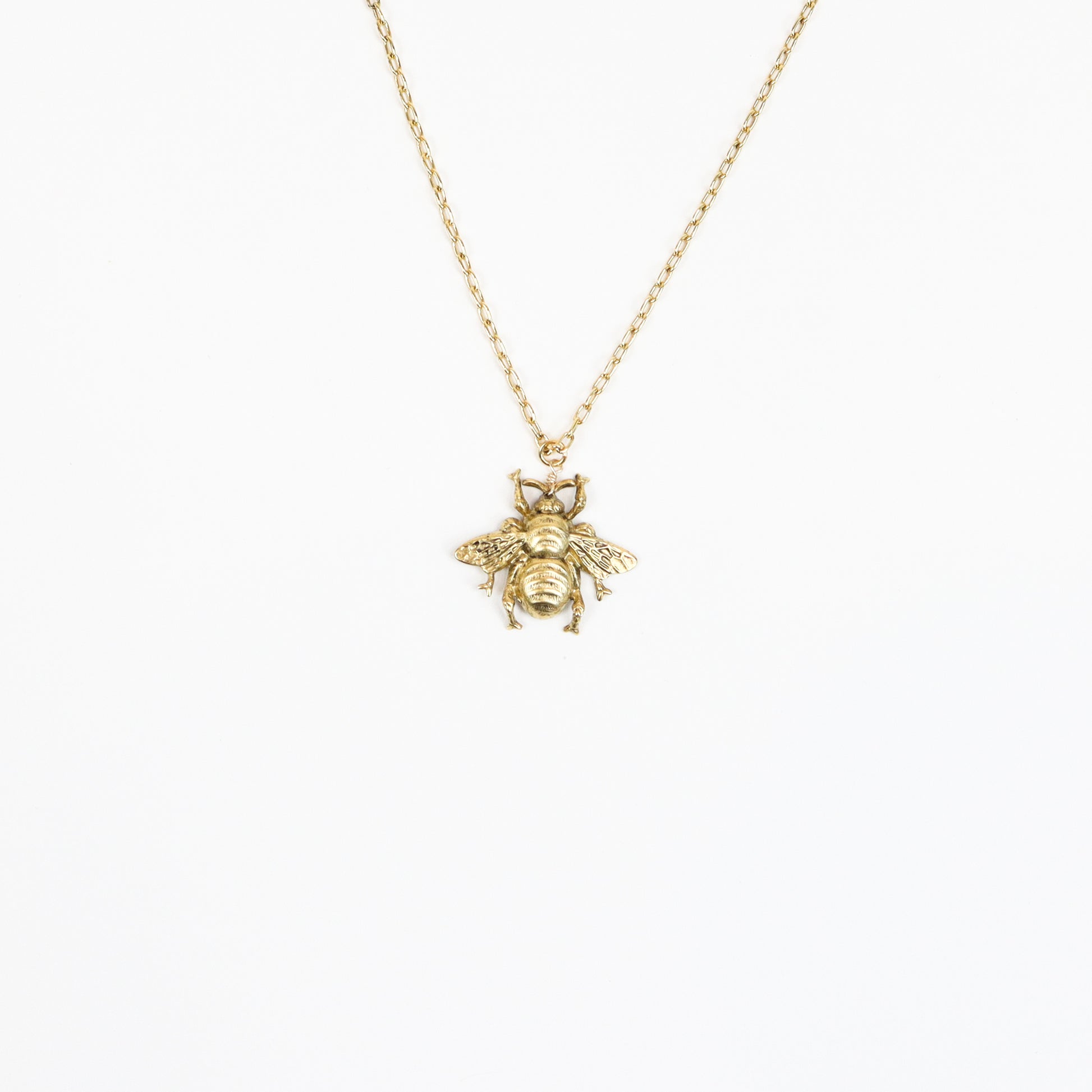  A handcrafted 22K gold-plated honeybee pendant necklace featuring intricate wing and body details, suspended on a delicate gold chain, embodying elegance and nature-inspired beauty.
