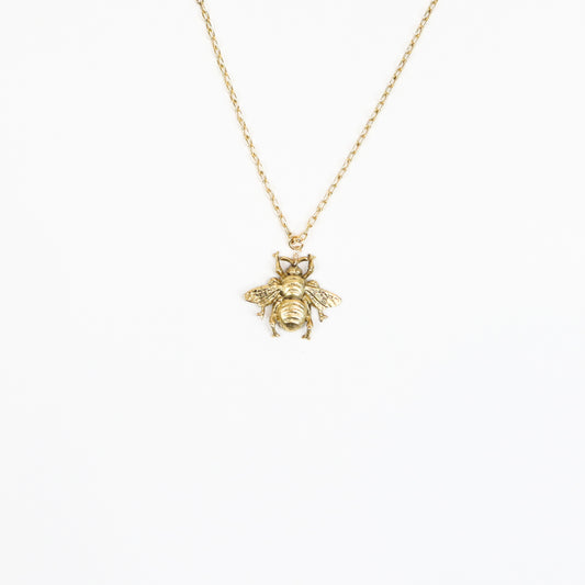  A handcrafted 22K gold-plated honeybee pendant necklace featuring intricate wing and body details, suspended on a delicate gold chain, embodying elegance and nature-inspired beauty.
