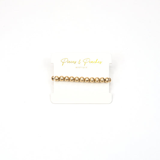 Gold statement earrings featuring an intricate textured design with a blend of brushed and polished finishes, offering a modern and elegant look