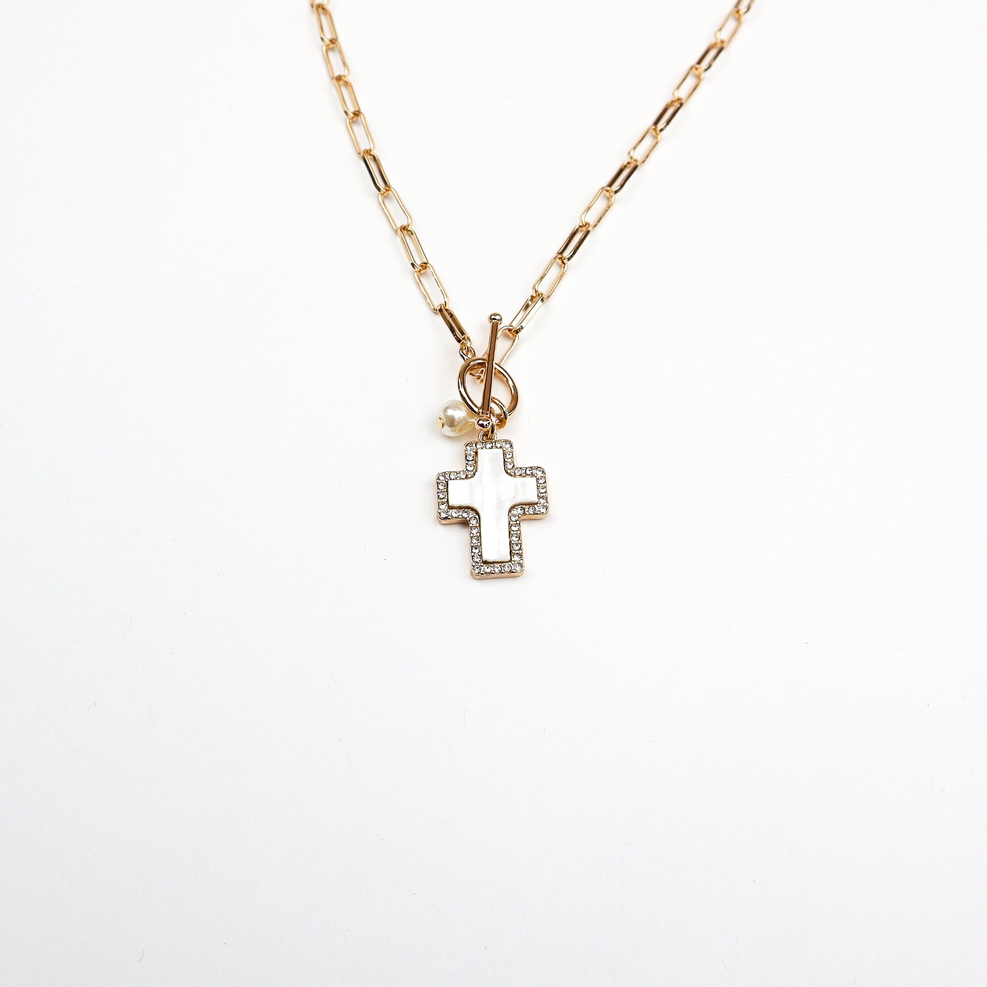 A chic gold cross charm necklace featuring a modern paperclip chain and a beautifully crafted cross pendant, perfect for layering or wearing alone.
