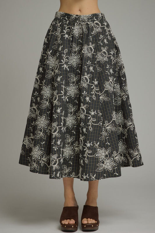 A timeless plaid midi skirt featuring delicate floral embroidery and a flattering silhouette for effortless everyday elegance.
