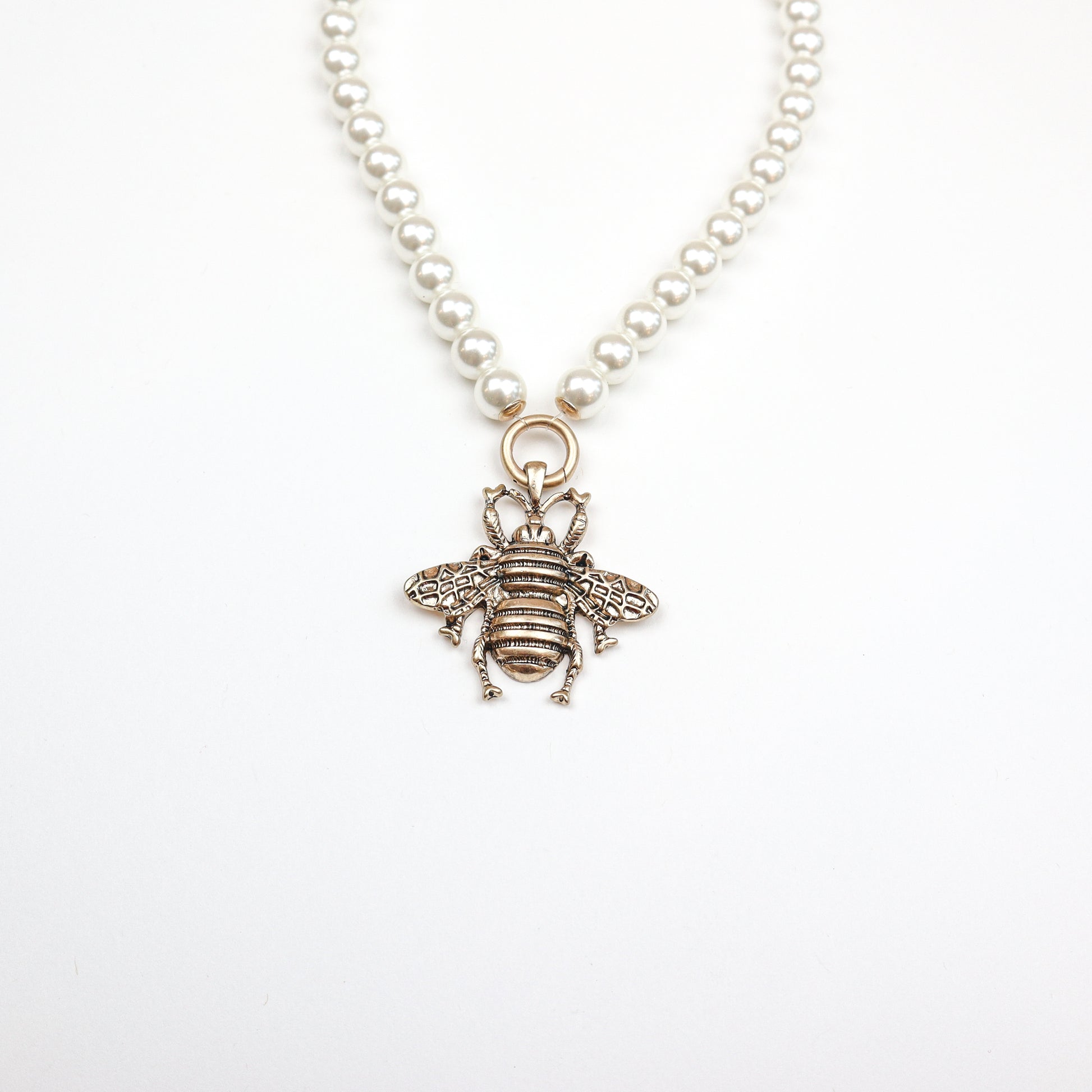 A stunning pearl necklace featuring an intricately designed bee pendant, blending elegance with nature-inspired charm.
