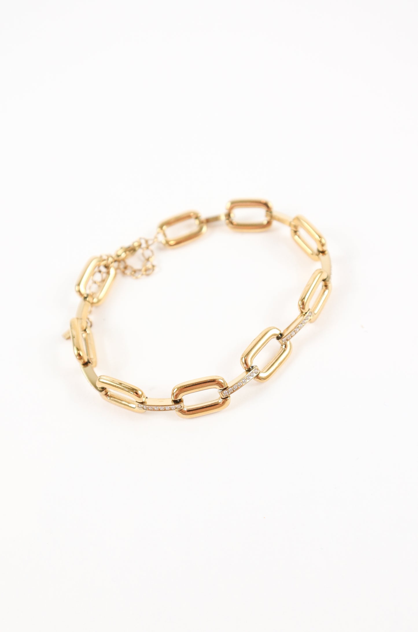Chunky gold link bracelet with pavé crystal accents and adjustable clasp on white background