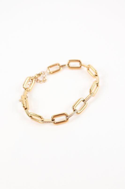 Chunky gold link bracelet with pavé crystal accents and adjustable clasp on white background