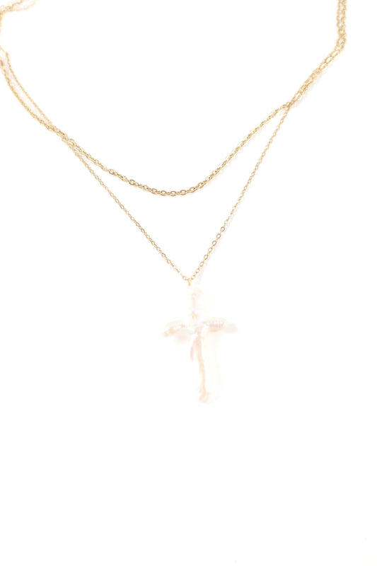Delicate double-layer gold necklace featuring a polished cross pendant on fine gold chains.