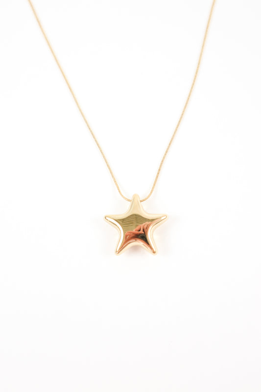 Polished gold star pendant necklace on a delicate gold chain with a high-shine reflective finish