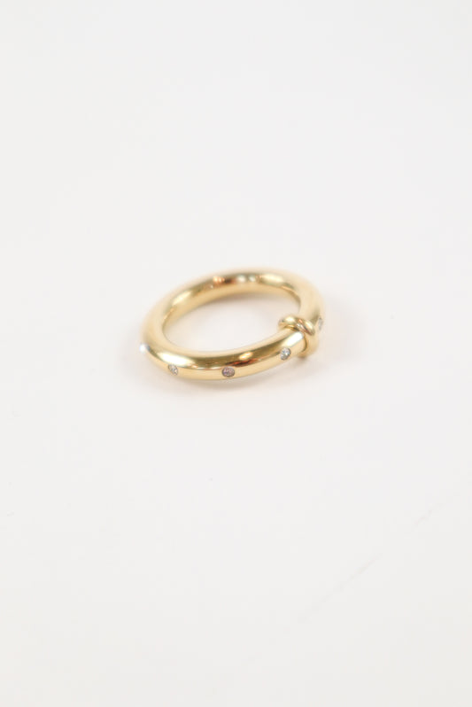 14K yellow gold knot ring with small round diamond accents on a polished minimalist band