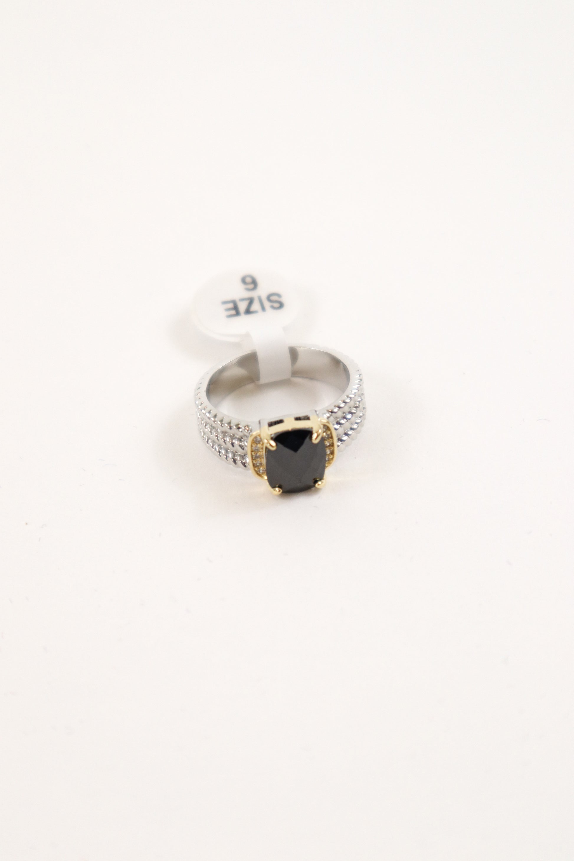 Mixed metal statement ring with black cushion-cut stone, gold prongs, and pavé crystal silver band