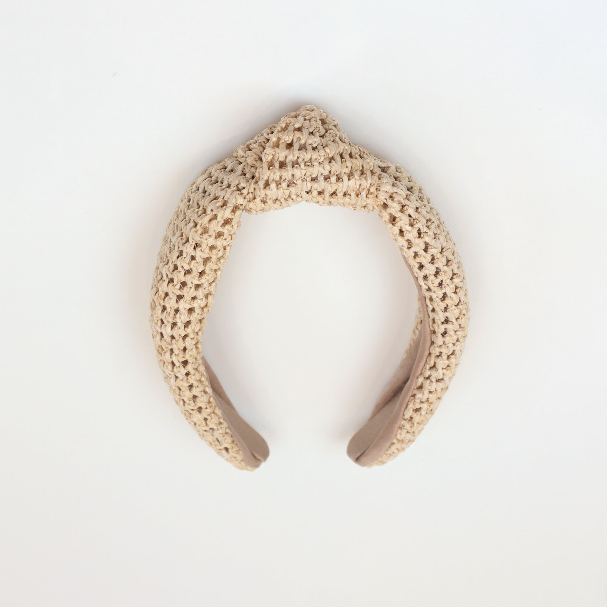 Natural woven rattan headband with a stylish knotted top, perfect for boho-chic fashion lovers