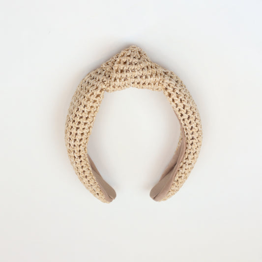 Natural woven rattan headband with a stylish knotted top, perfect for boho-chic fashion lovers