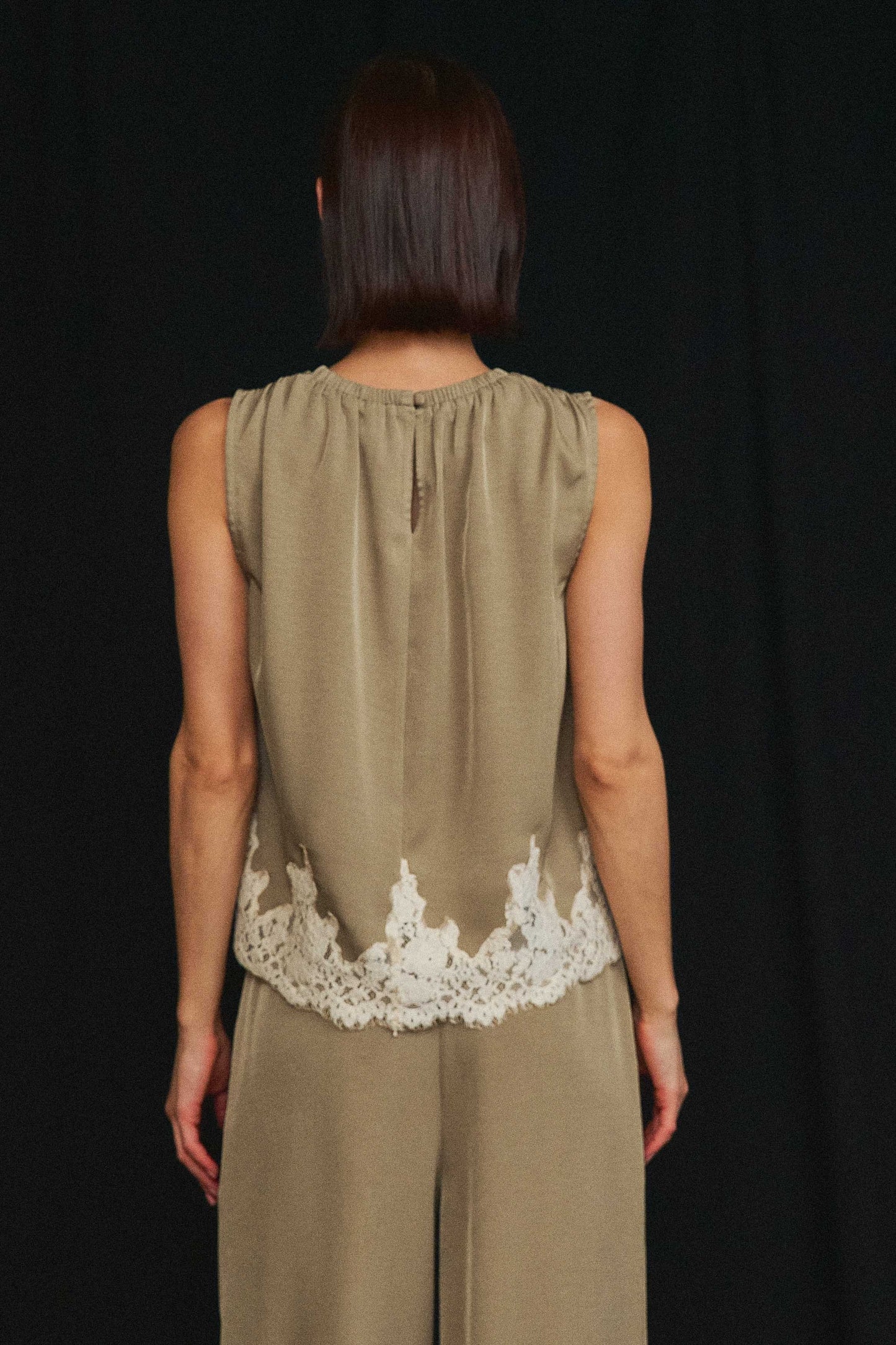 An effortlessly elegant two-piece set featuring delicate lace trim, a gathered neckline, and flowing wide-leg pants for timeless sophistication.
