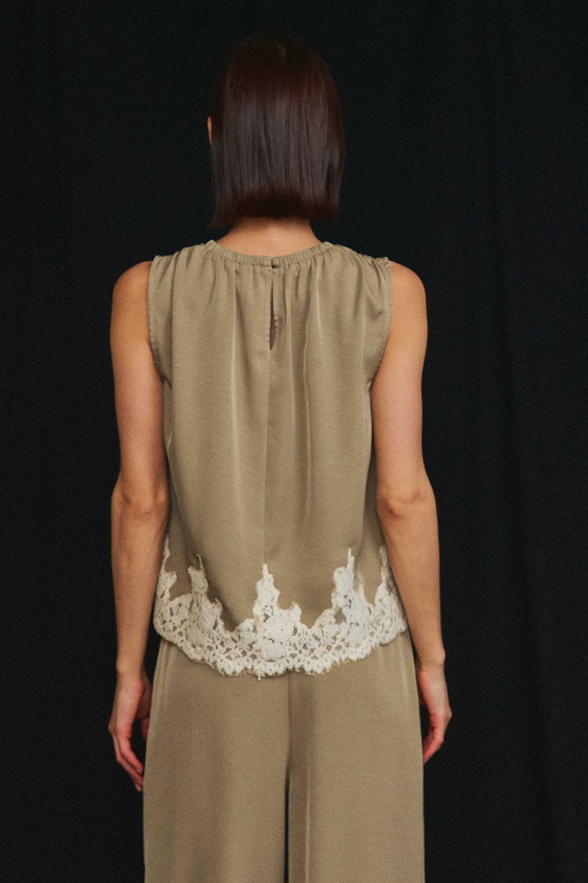 An effortlessly elegant two-piece set featuring delicate lace trim, a gathered neckline, and flowing wide-leg pants for timeless sophistication.
