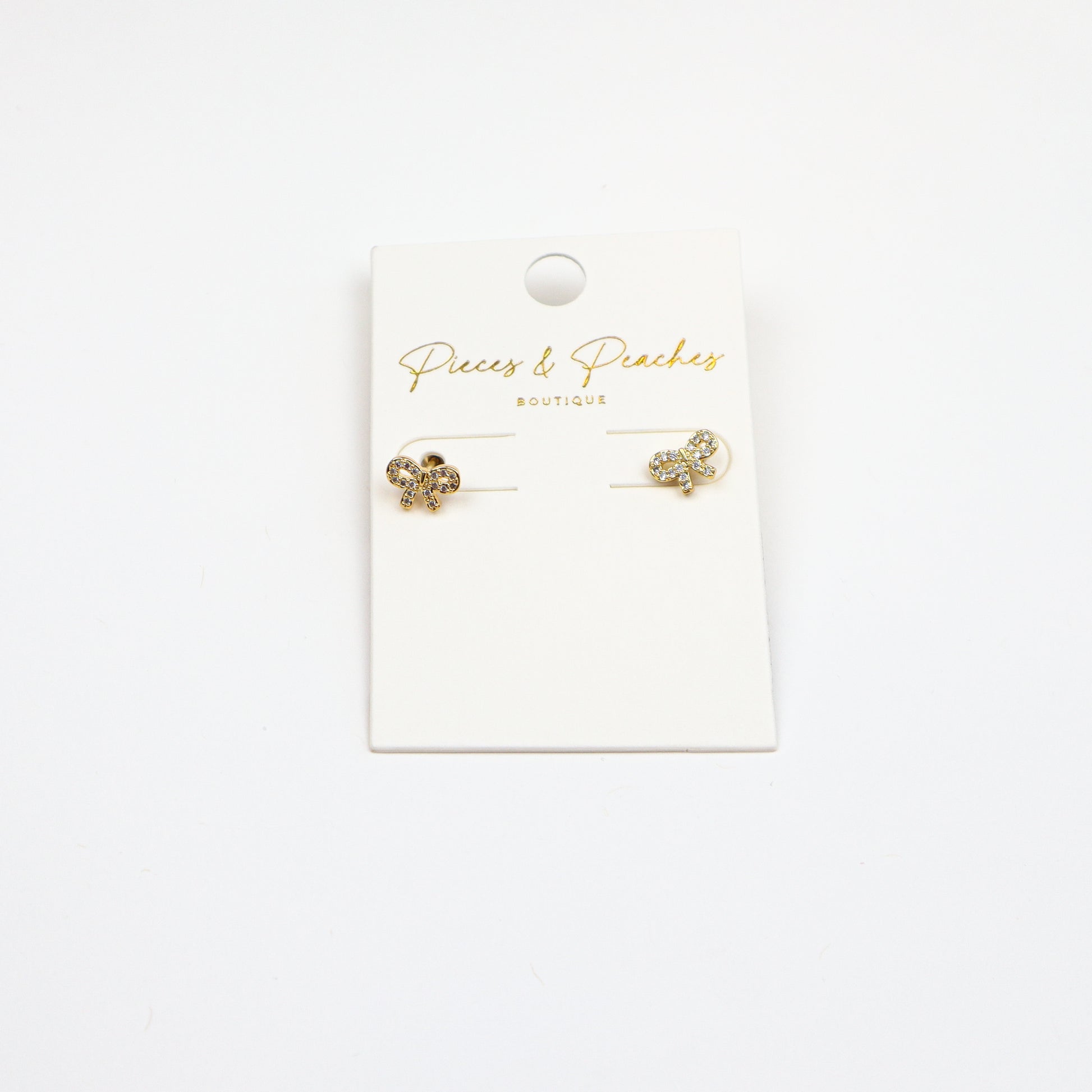 Dainty gold bow stud earrings with cubic zirconia accents