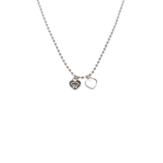 Silver beaded chain necklace with two heart charms, featuring a polished finish and engraved detailing for a timeless, elegant look