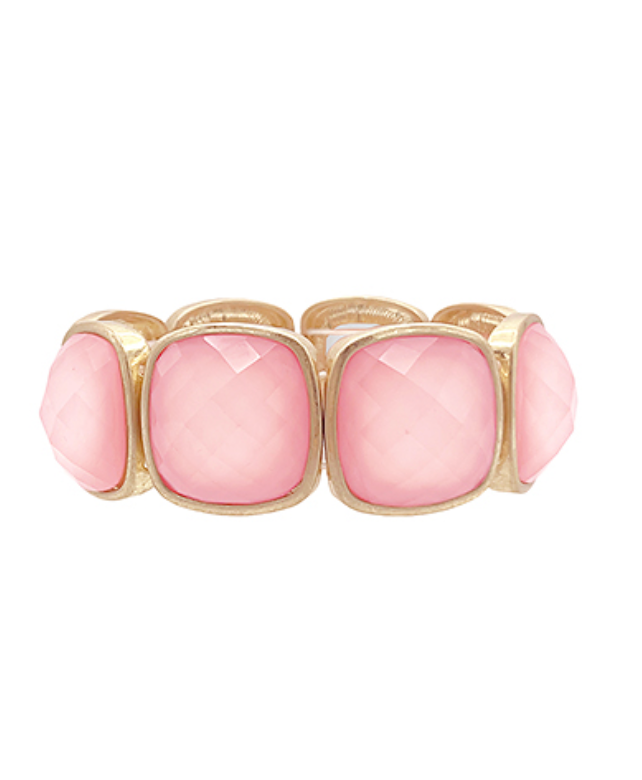 A gold-colored metal bracelet with multifaceted pink gemstones set in a stretch design.