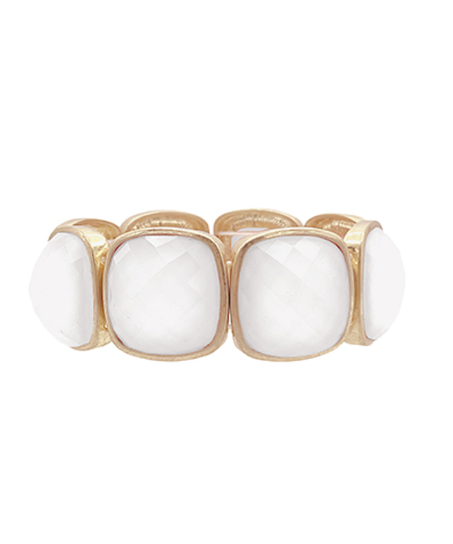 A gold-colored metal bracelet with multifaceted white gemstones set in a stretch design.