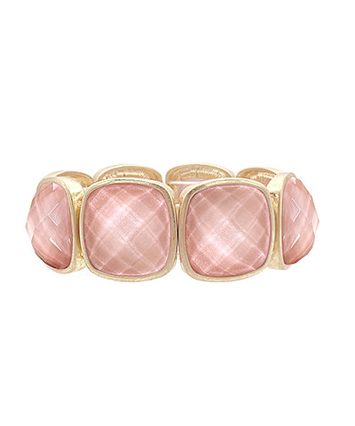 A gold-colored metal bracelet with multifaceted light pink gemstones set in a stretch design.