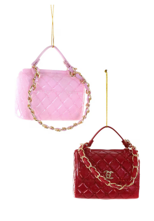 Two Luxe Handbag Ornaments in pink and red, featuring quilted textures and gold-tone chain accents, hanging elegantly against a white background.