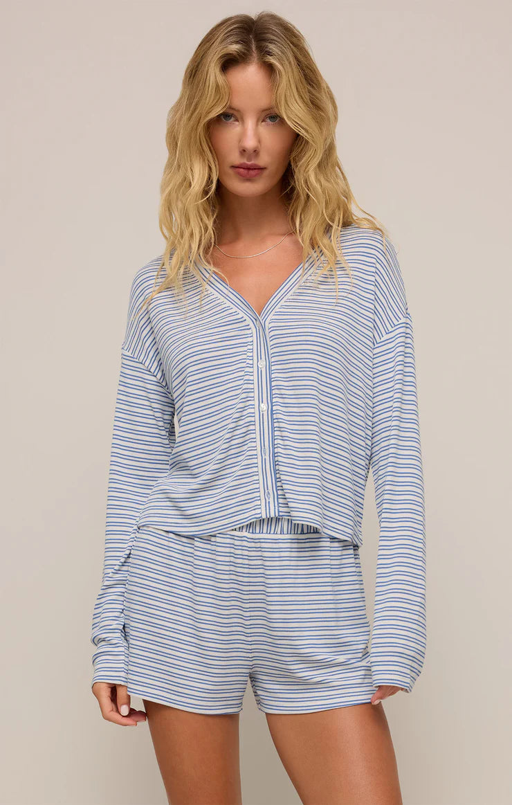 Model wearing the Mara Stripe Modal Cardigan Set, featuring a relaxed-fit button-up top and matching high-waisted shorts in soft blue and white stripes.