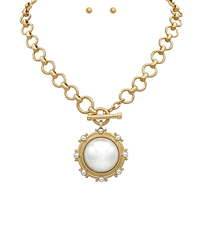 Gold chain necklace with toggle clasp and round faux pearl medallion pendant.