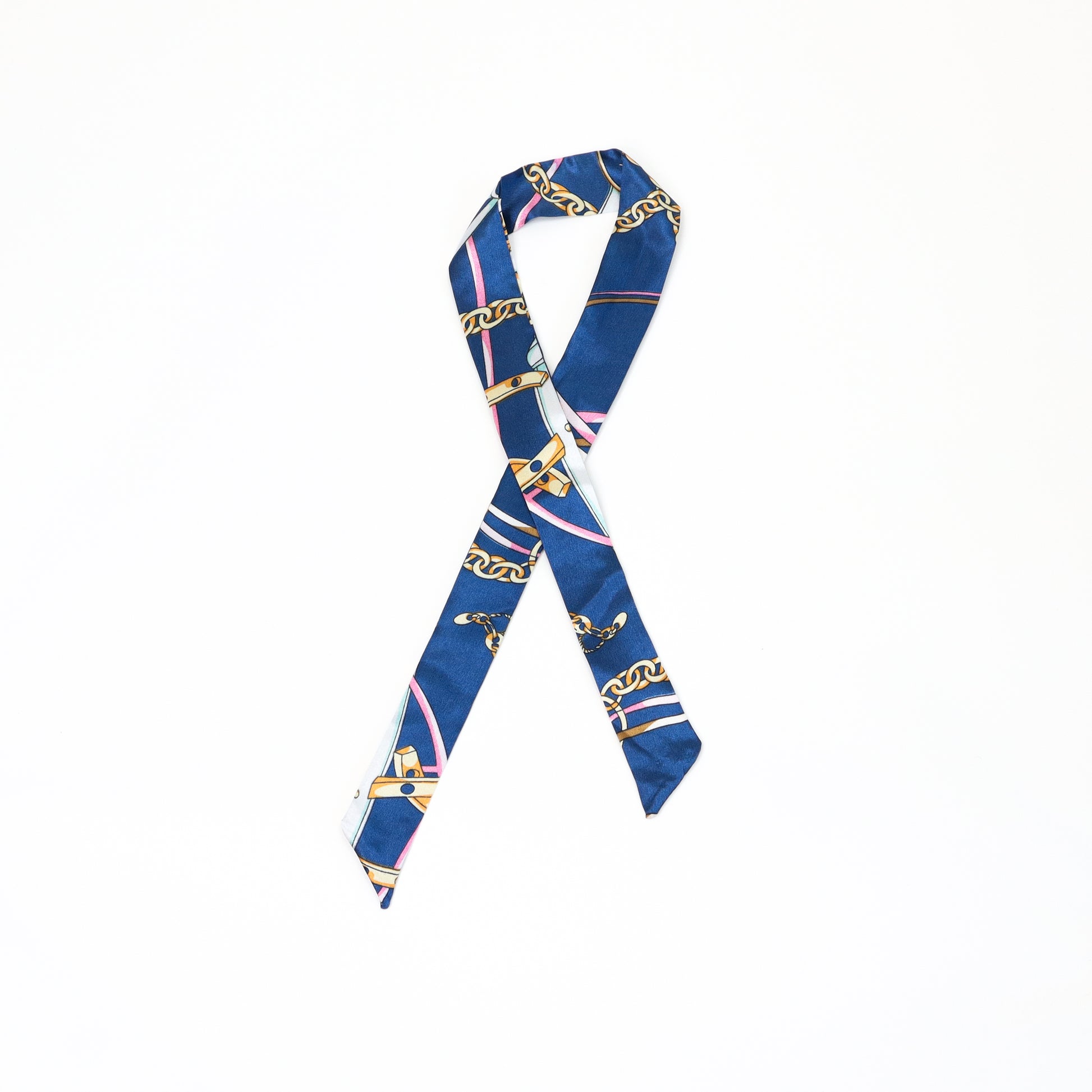 A navy blue twilly scarf with gold equestrian-inspired chain designs