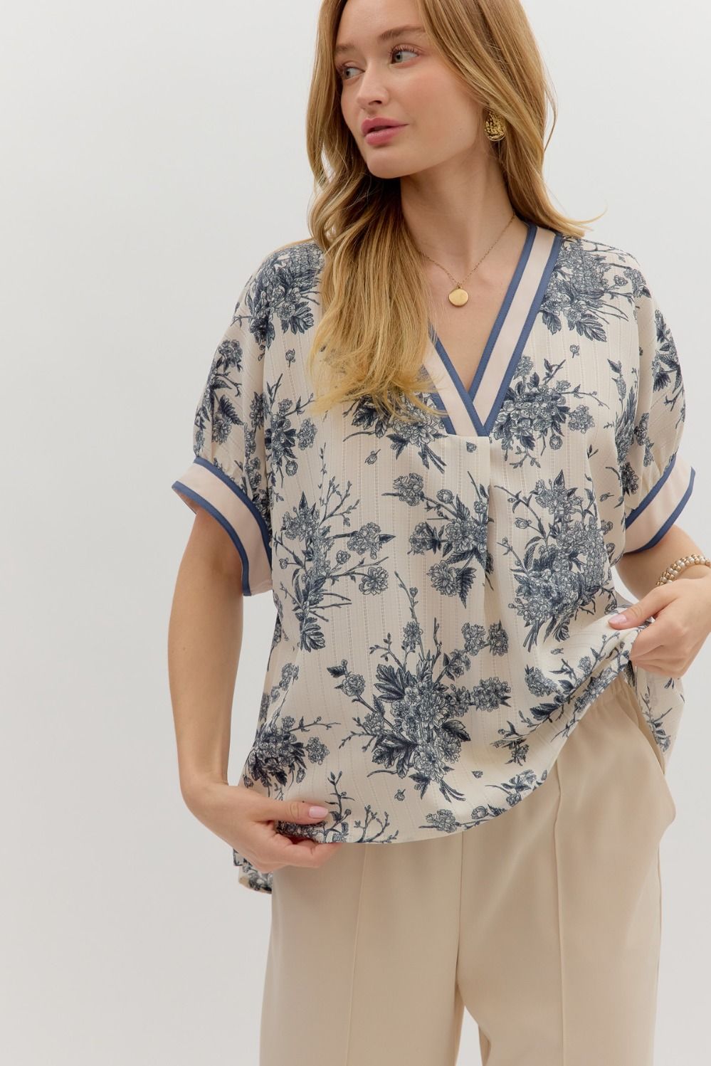Oversized floral pullover top with short dolman sleeves and a vibrant multicolor band detail.