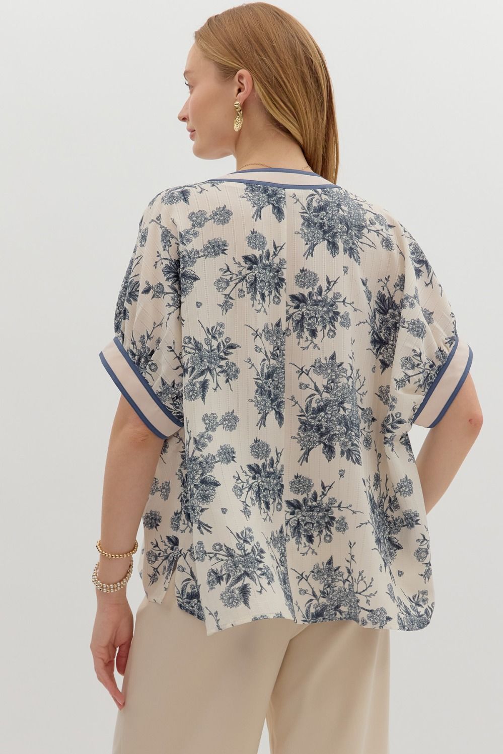 Oversized floral pullover top with short dolman sleeves and a vibrant multicolor band detail.

