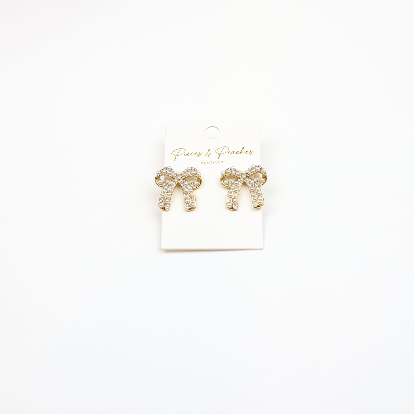 Elegant Pearl Bow Earrings featuring a gold-tone finish, sparkling crystals, and pearl embellishments, perfect for timeless and sophisticated styling.