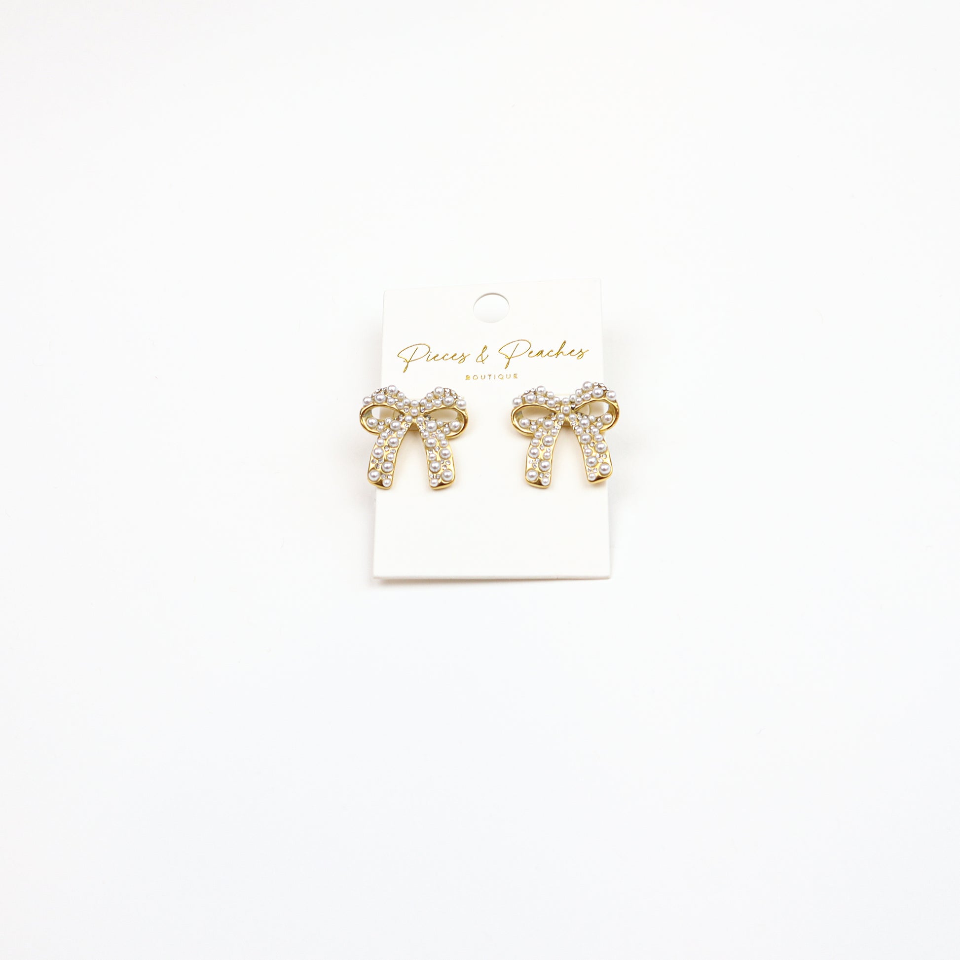 Elegant Pearl Bow Earrings featuring a gold-tone finish, sparkling crystals, and pearl embellishments, perfect for timeless and sophisticated styling.