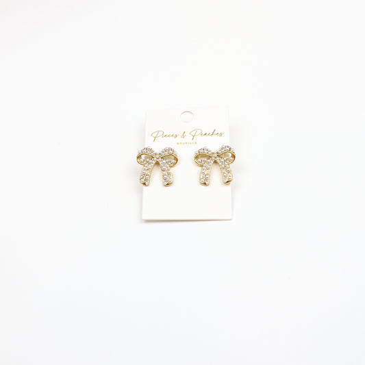 Elegant Pearl Bow Earrings featuring a gold-tone finish, sparkling crystals, and pearl embellishments, perfect for timeless and sophisticated styling.
