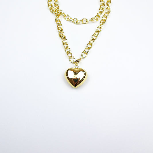 A chic layered gold necklace featuring a bold heart pendant, perfect for adding a touch of romance and elegance to any look.
