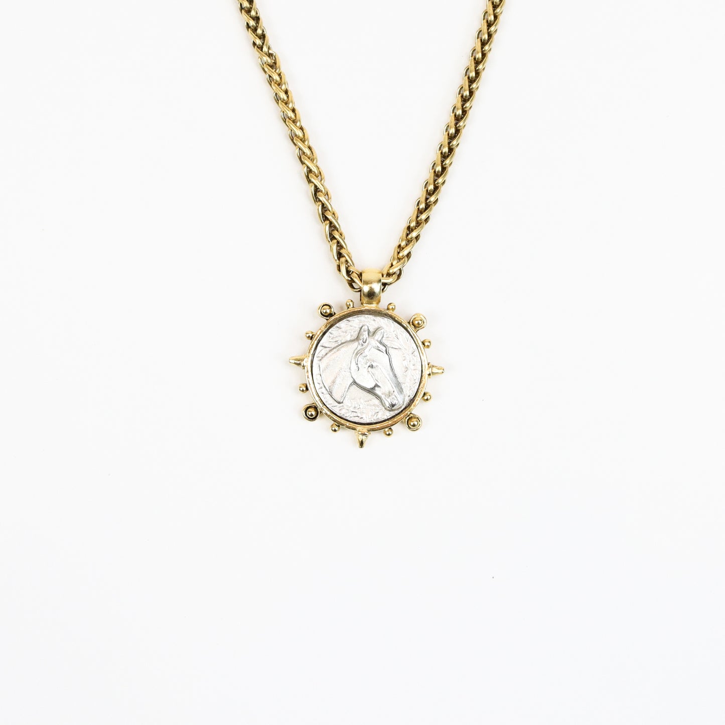  A 22K gold-plated equestrian-inspired necklace featuring a detailed stallion medallion pendant encased in a sunburst-style frame, suspended from a bold gold chain.