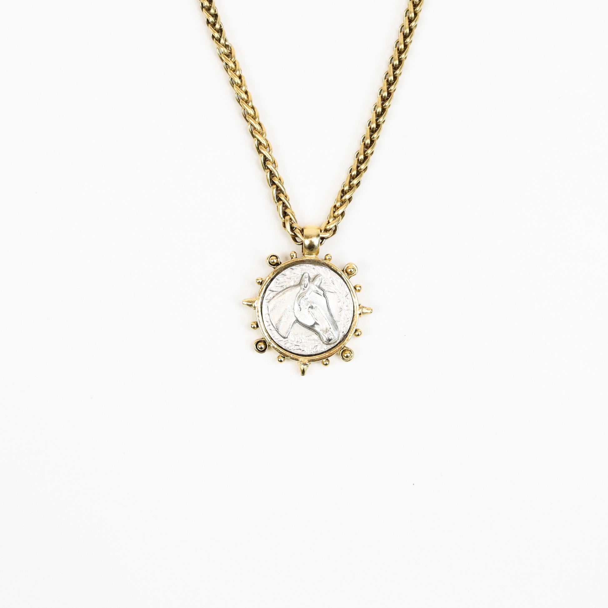  A 22K gold-plated equestrian-inspired necklace featuring a detailed stallion medallion pendant encased in a sunburst-style frame, suspended from a bold gold chain.