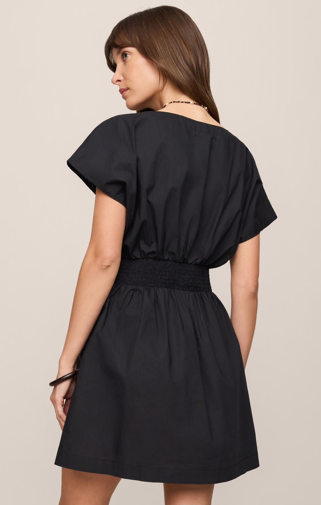 back of cotton poplin mini dress featuring a flattering V-neckline, short sleeves, and elasitic waist.