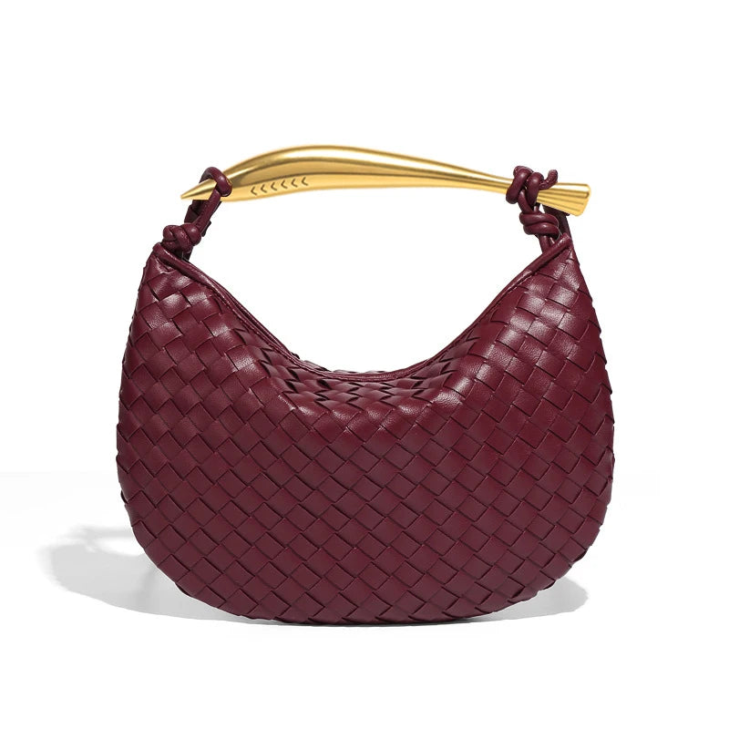 woven leather handbag with a bold gold sculptural handle for a modern, luxury look.