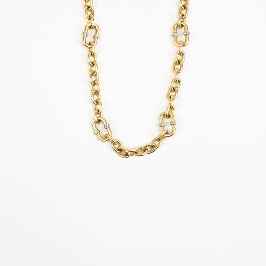 A 22K gold-plated chain necklace featuring bold interlocking links with crystal-accented connectors, exuding luxury and elegance.