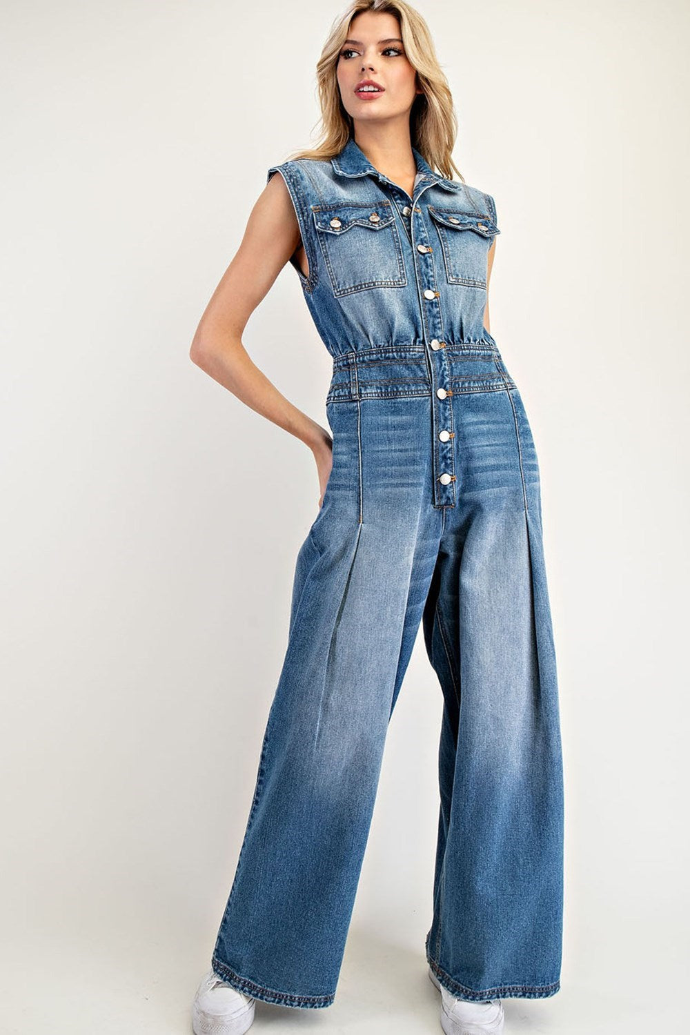 Snow washed sleeveless jumpsuit with button front, chest pockets, and wide leg silhouette.