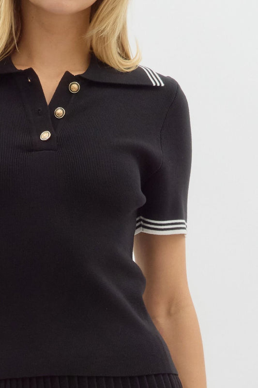 Solid sweater knit short sleeve polo top featuring accented gold buttons. Stripe pattern accent over collar and sleeve. Unlined. Knit. Non-sheer. Lightweight.