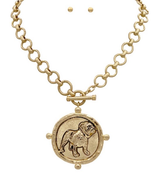 A bold gold-toned medallion necklace featuring an intricately detailed bulldog pendant on a chunky chain with a toggle clasp.

